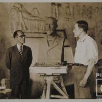 John Portuguez con busto de Mauro Fernández en taller, al fondo esta el relieve El sueño por Portuguez Fucigna, John. Documental